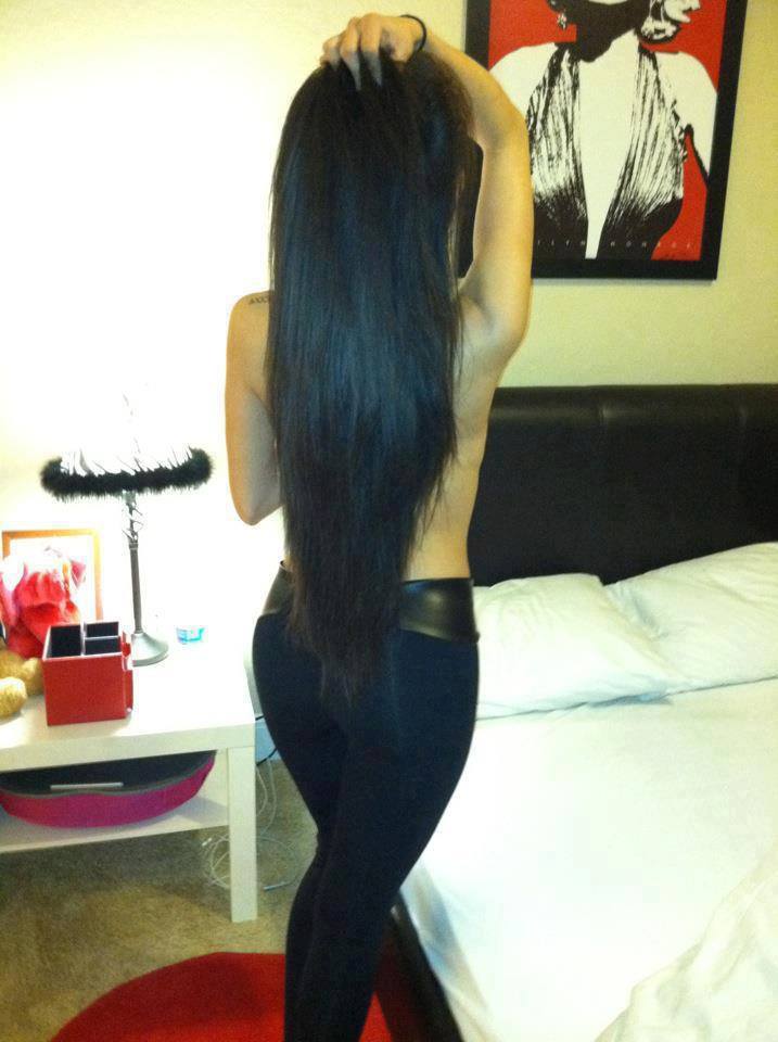 Молодая девушка с длинными черными волосами голая перед зеркалом