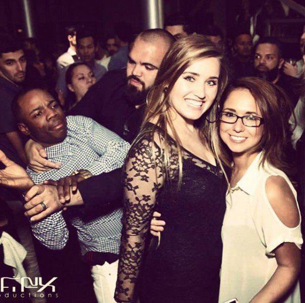 Funny photo bomb of black man being subdued as two white girls are taking their picture