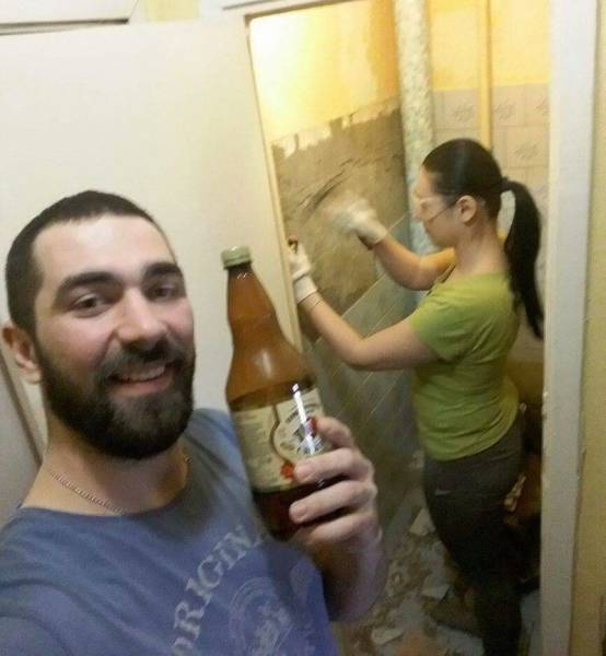 Cool pics - Dude is drinking a beer while his girl is doing construction work in the background.
