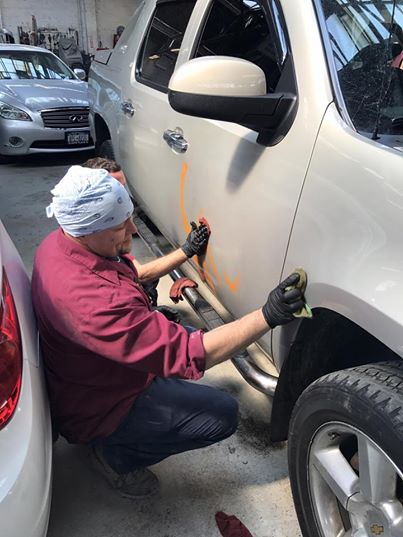 Worker looking at defaced pickup truck