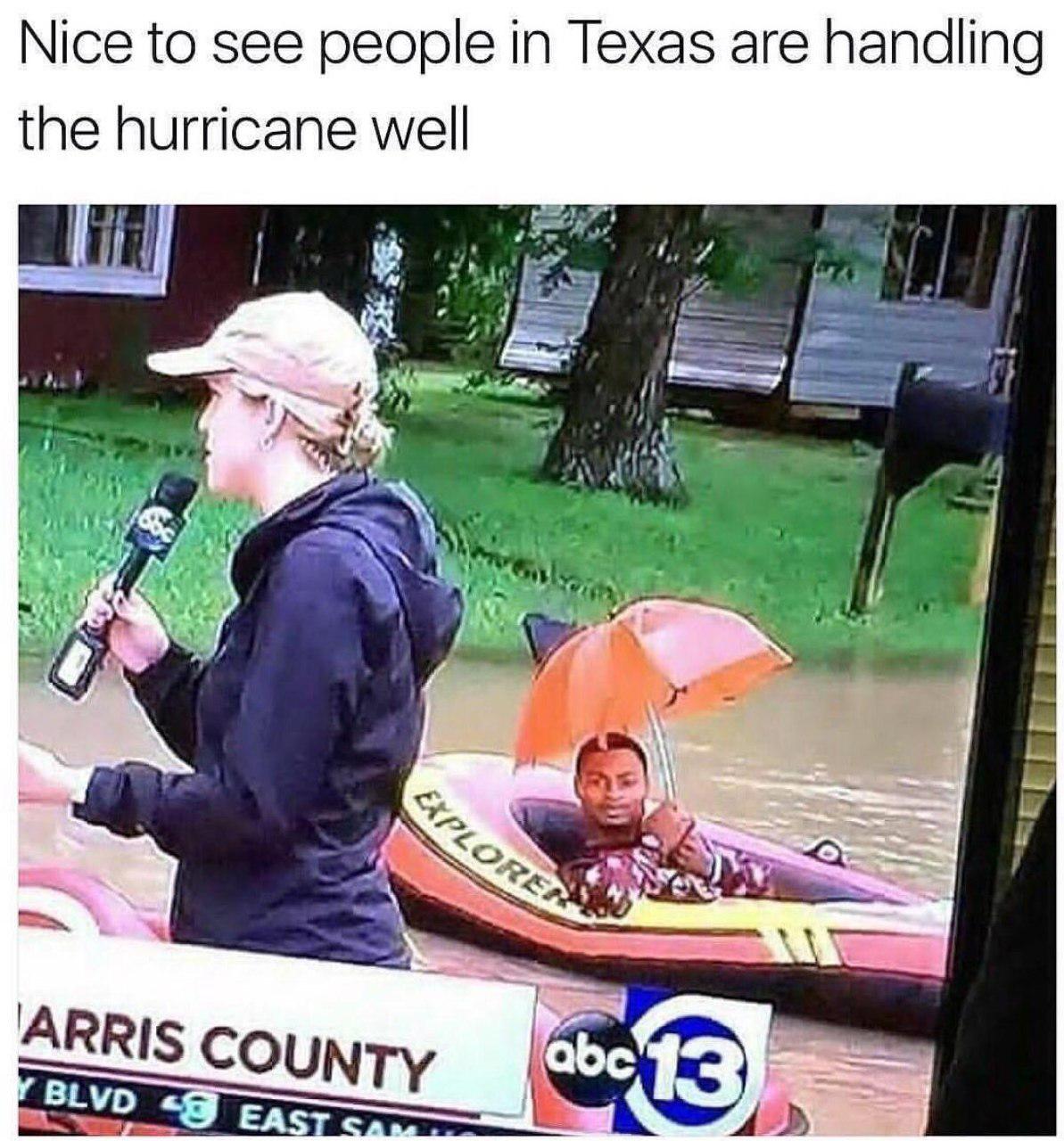 Man in a boat with sunbrella after the hurricane in Texas.