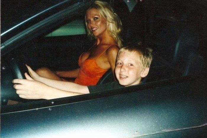 Kid driving and his mom looks like Pamela Anderson