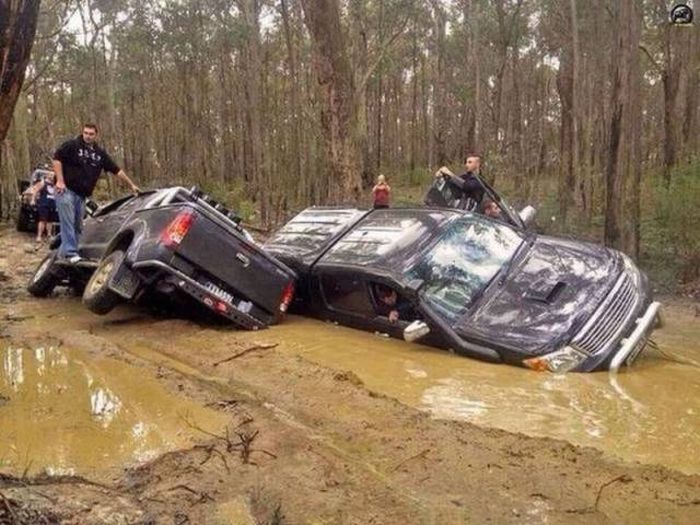 Two pickup trucks that fell into a massive mud hole or pot hole