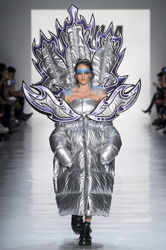 Woman wearing puffy coat on the fashion runway that looks like the iron throne.