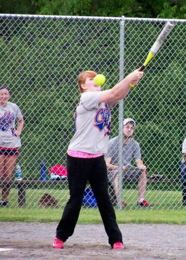 Girl swinging a bat and about to be hit in the face with the ball