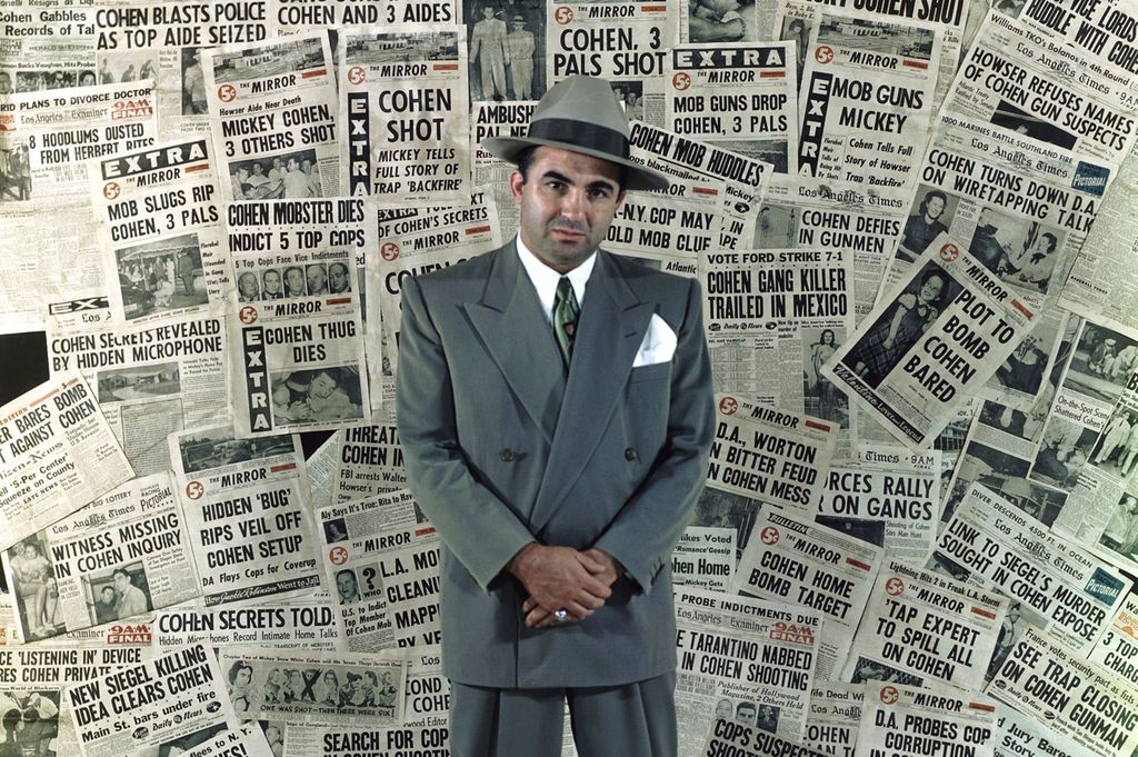 Gangster Mickey Cohen standing amongst the front pages of newspapers that helped make him the city’s’ most infamous citizen – 1960.