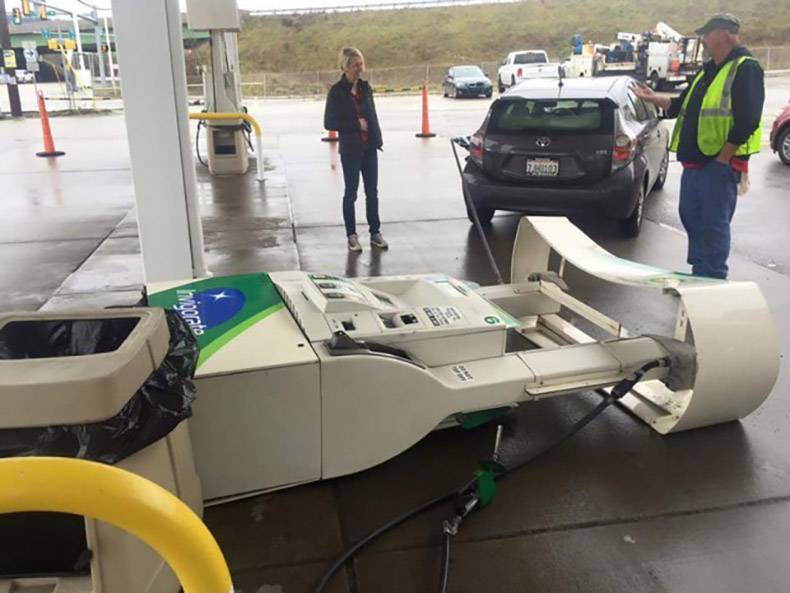 Hilarious picture of woman who drove away from gas pump without pulling it out and it knocked over the fueling station