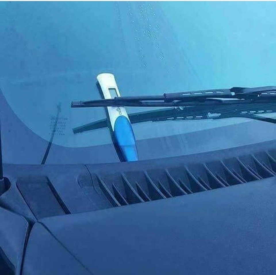Pregnancy test left under a windshield wiper of a car