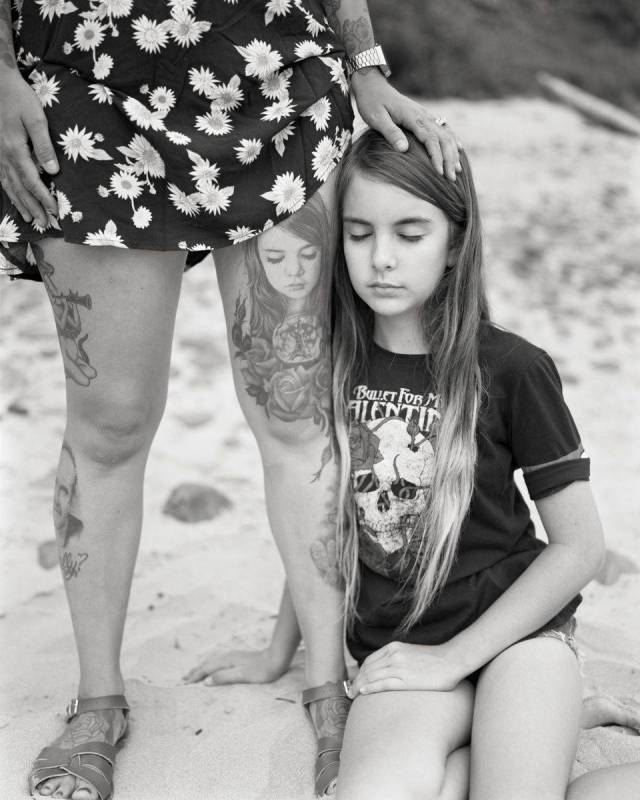 Black and white photo of girl and the tattoo of her on mother's thighs