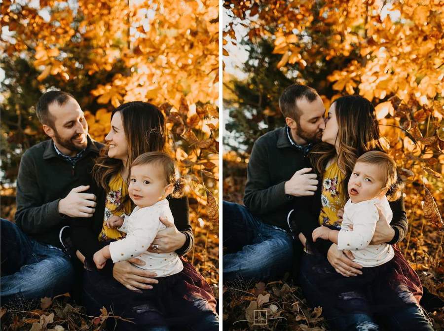 couple making out in the fall with baby making funny faces