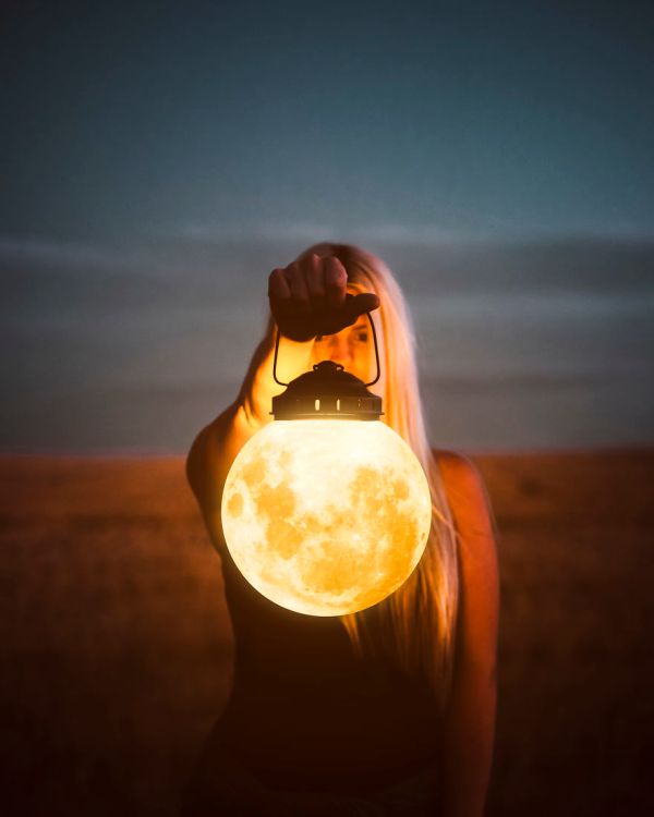 woman holding lantern that looks like the moon