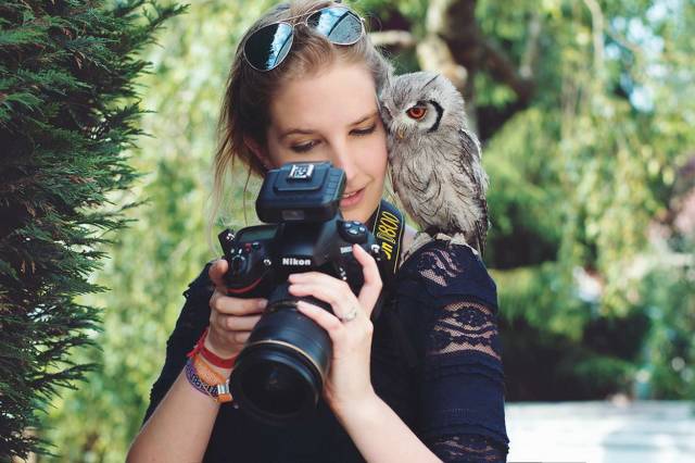 female photographer showing an owl the latest shot