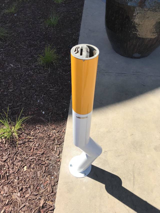 public ashtray that looks like a large extinguished cigarette