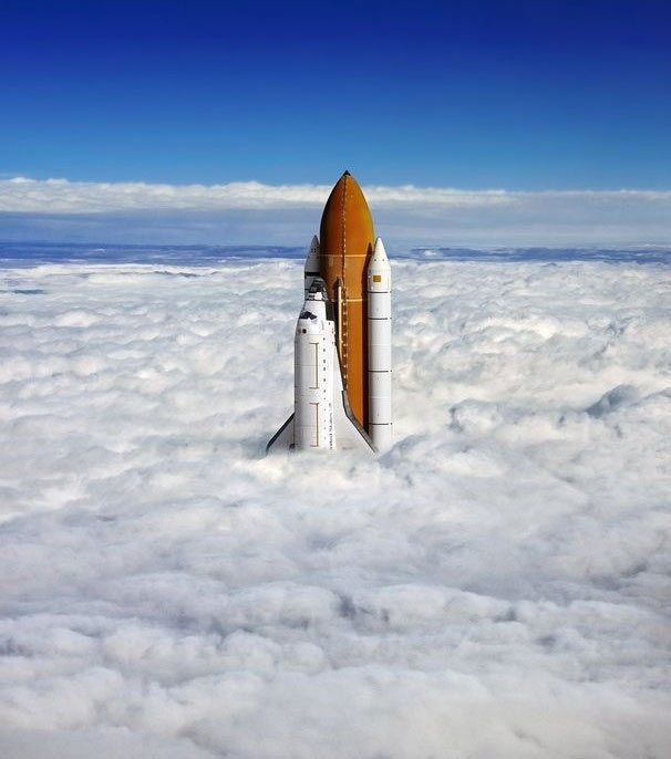 Space shuttle poking through the clouds