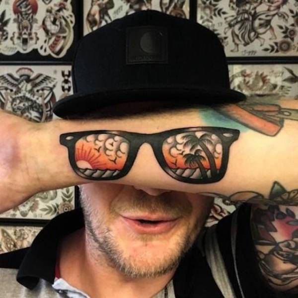 man with chill sunglasses tattoo on his forearm