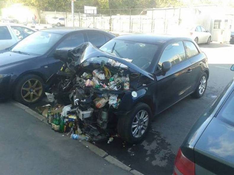 trashed crashed car with junk under the hood