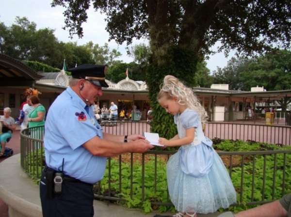 A park security officer makes a little girl's day by asking the "princess" for her autograph.