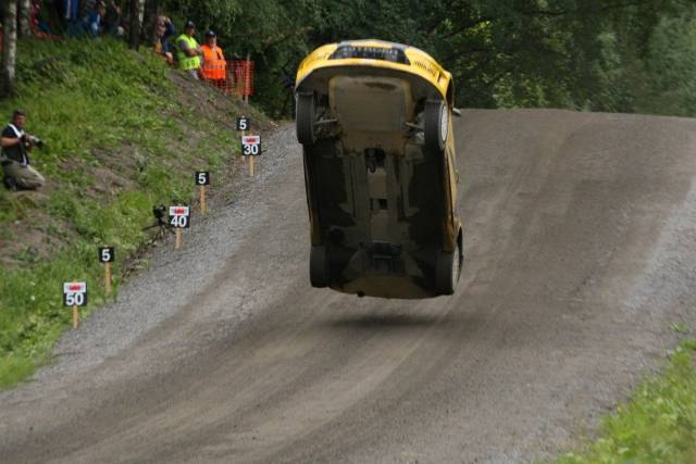 car doing mid air wheelie over a mound in a race