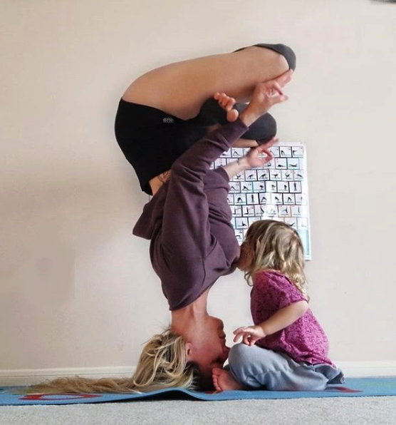 yoga mom breastfeeding while doing a headstand