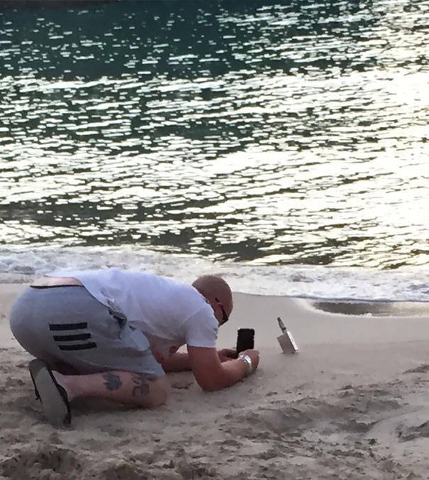 man taking picture of vape on beach