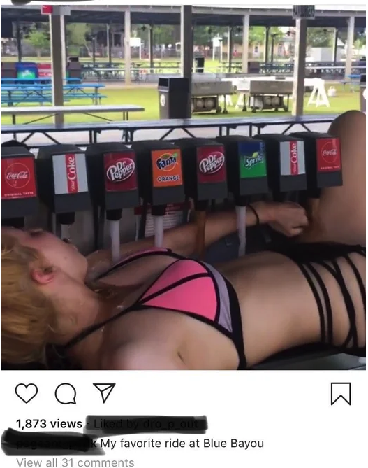 woman laying under a soda machine