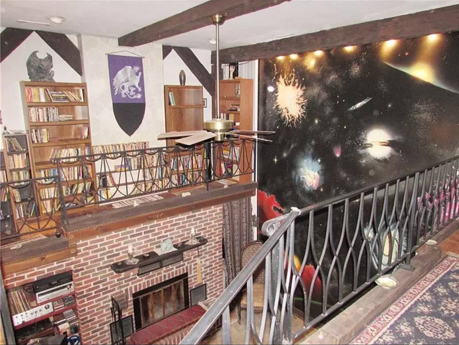 house with medieval bookcase and outer space galaxy mural