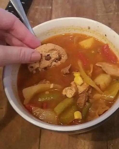 dipping a chocolate chip cookie into a bowl of chicken soup
