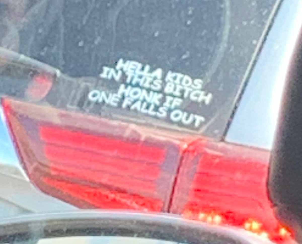 Funny picture of a car window sticker that says 'hella kids in this bitch honk if one falls out'