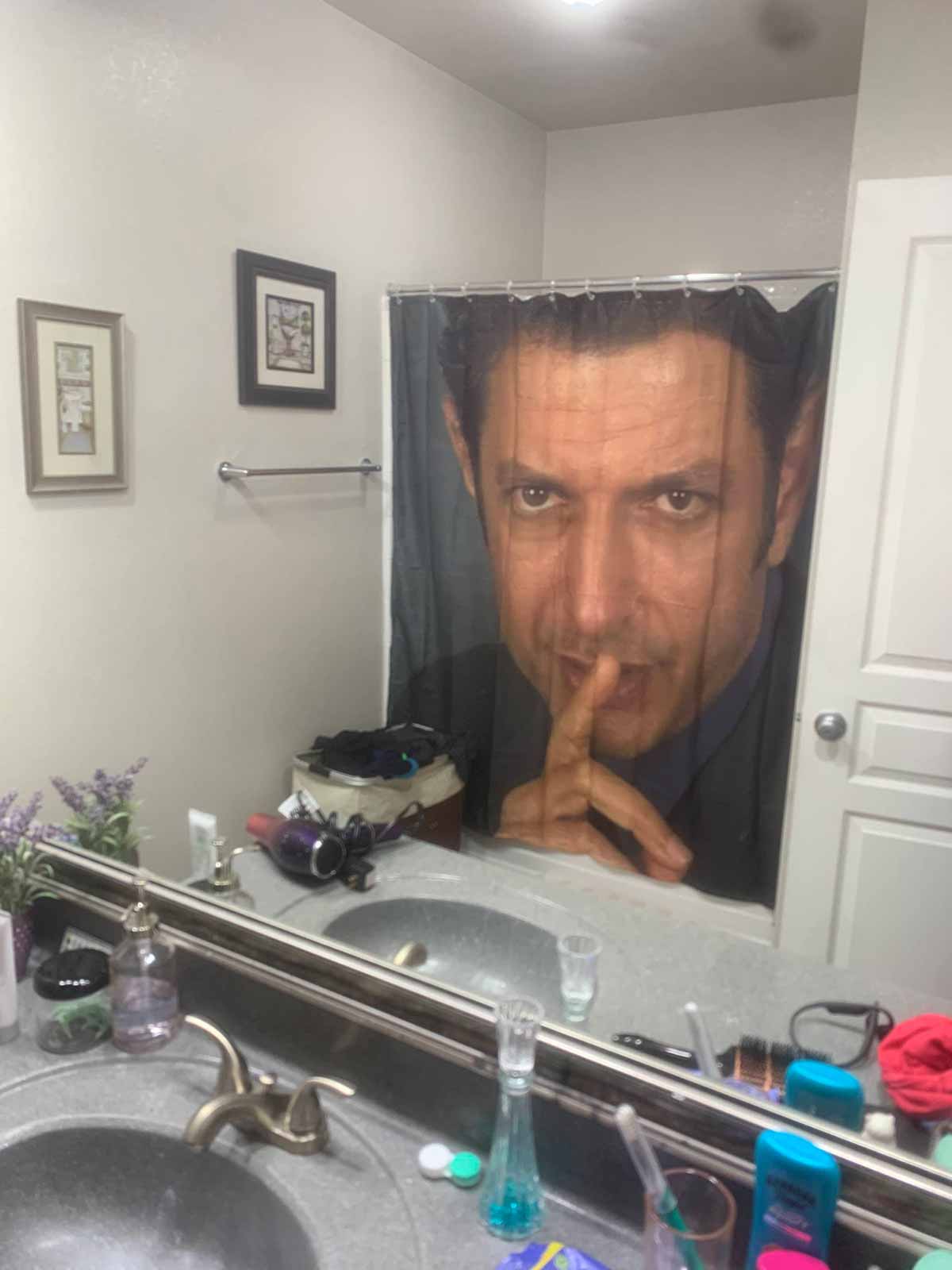 Jeff Goldbloom making the shhh gesture on a shower curtain