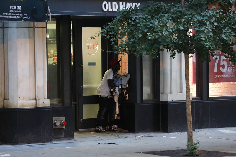 guy holding clothes outside old navy after chicago august 2020 looting