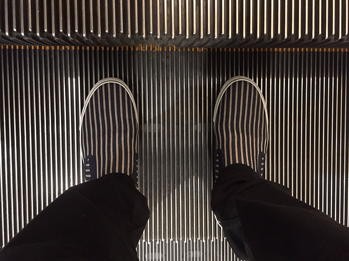 striped shoes lining up with escalator