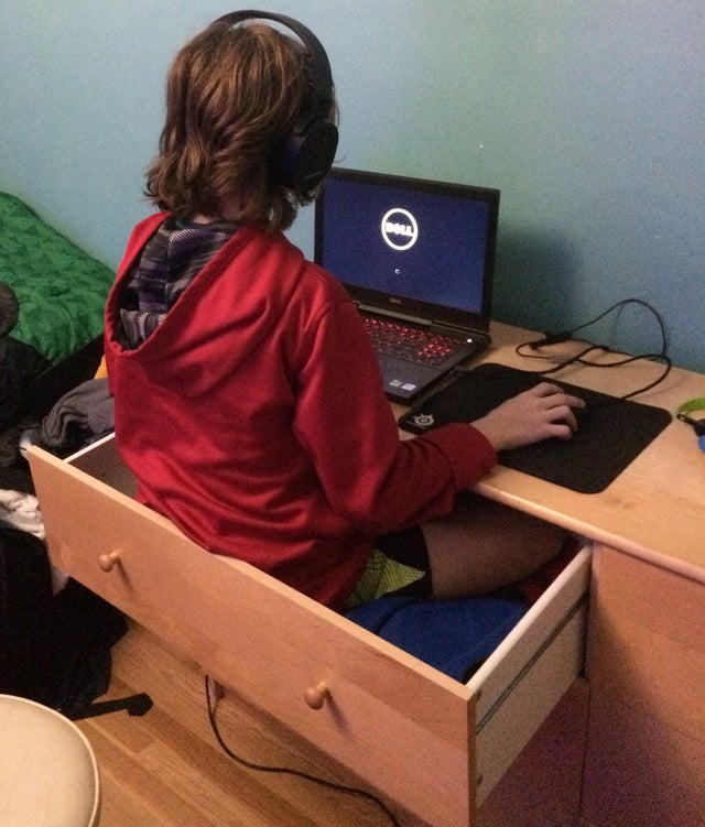 gaming set up kid playing sitting inside a drawer