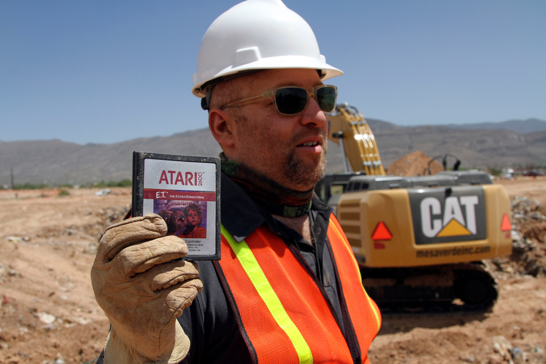 guy holding up uncovered atari e.t. game