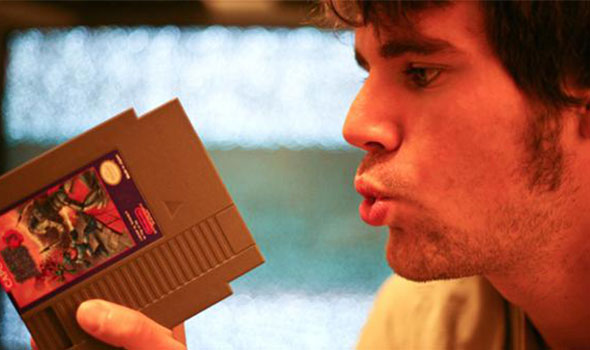 guy blowing into a video game cartridge