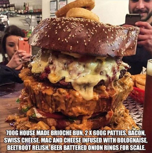 massive things -  hamburger giant - 700G House Made Brioche Bun, 2 X 600G Patties, Bacon, Swiss Cheese, Mac And Cheese Infused With Bolognaise, Beetroot Relish, Beer Battered Onion Rings For Scale.