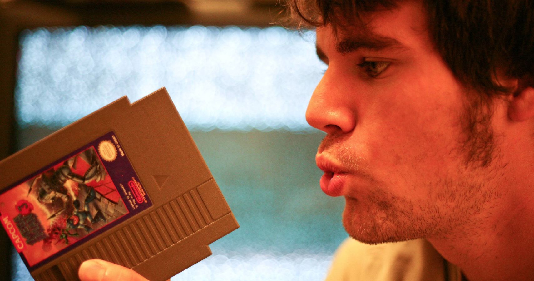 video game urban legends - guy blowing into nintendo video game cartridge