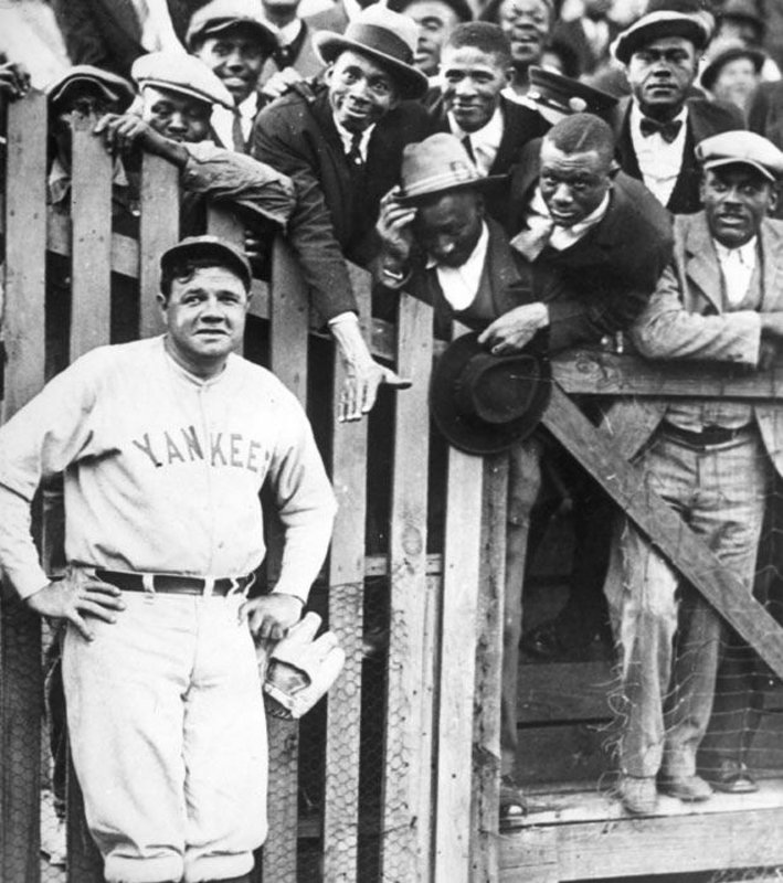 Babe Ruth posing with fans 1925. He was a popular figure in the African American community because of his willingness to treat them as he would white fans, along with rumors of him being biracial.