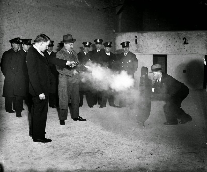 Frank Ballou and Samuel Peterson test out a new metal bulletproof shield. The shield’s inventor, Elliot Wisbrod, is the man holding it.