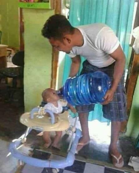 people with no common sense - man giving baby water jug - skan