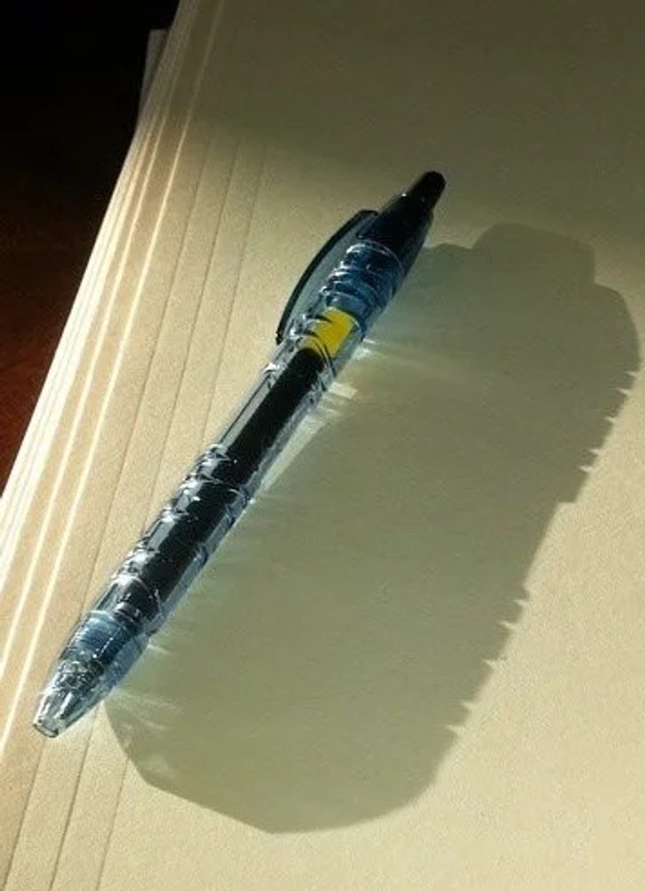 A pen made of recycled water bottles casts a shadow of a water bottle.