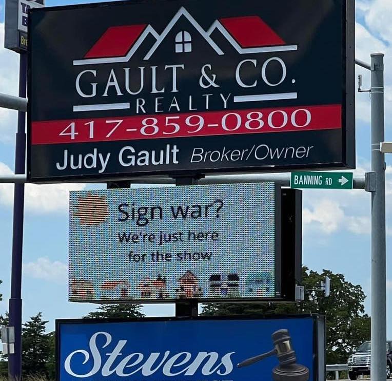Fast food sign war - street sign - Bre Gault&Co. Realty 4178590800 Judy Gault BrokerOwner Sign war? We're just here for the show Stevens Banning Rd www u inz