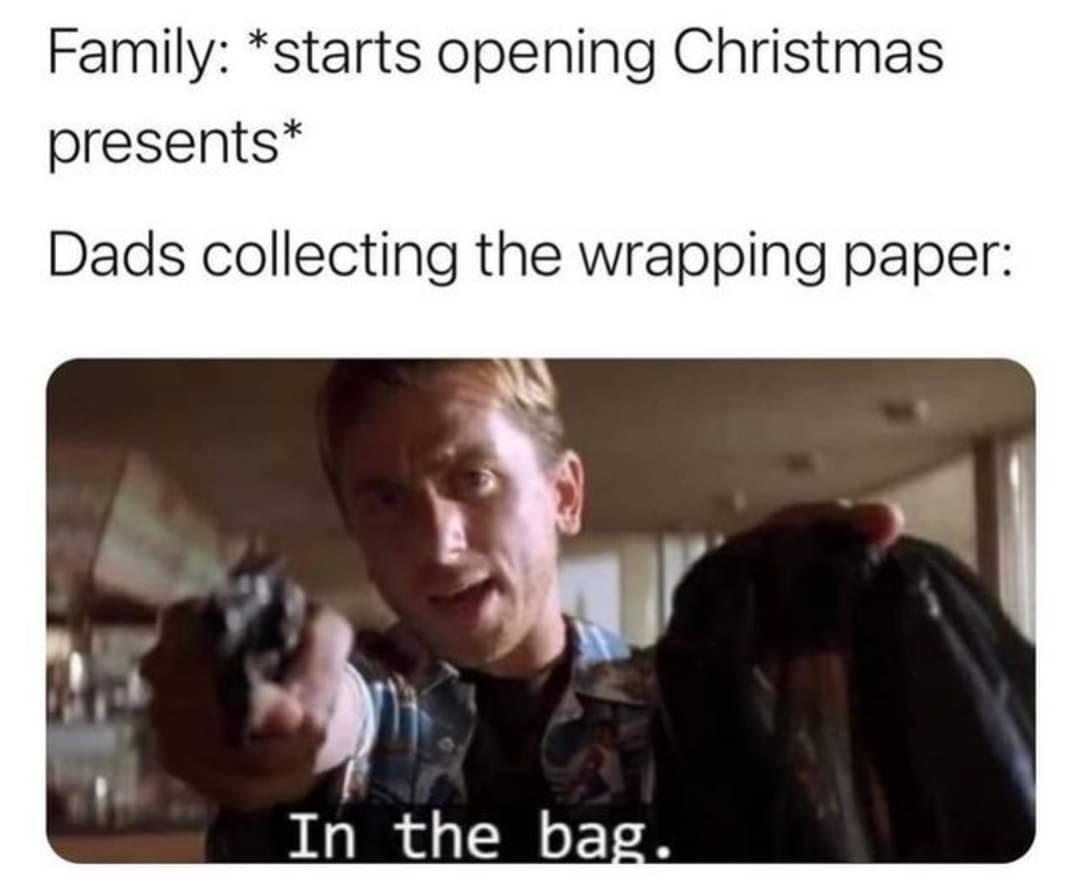photo caption - Family starts opening Christmas presents Dads collecting the wrapping paper In the bag.