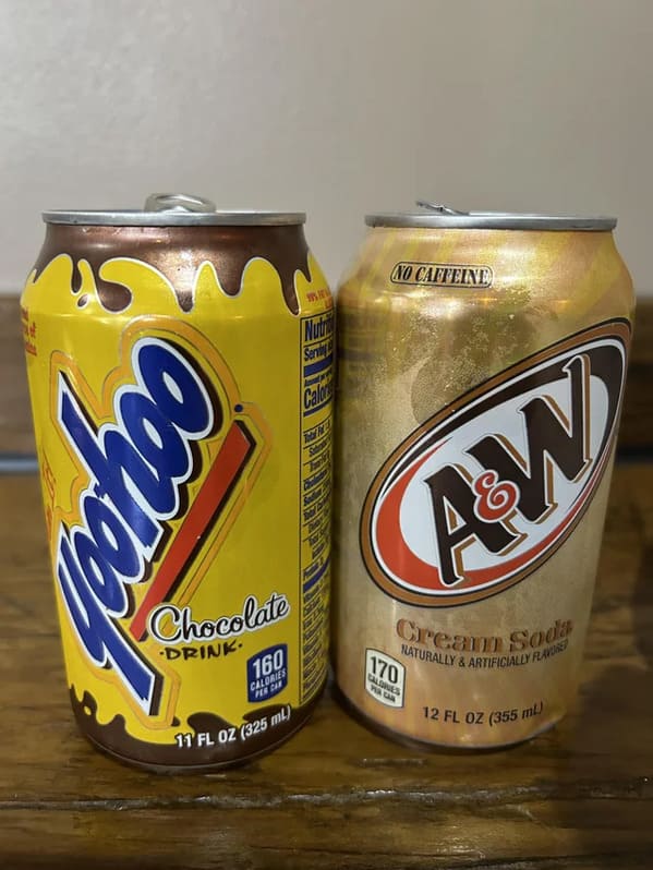 "Two cans with different amounts of beverage inside."