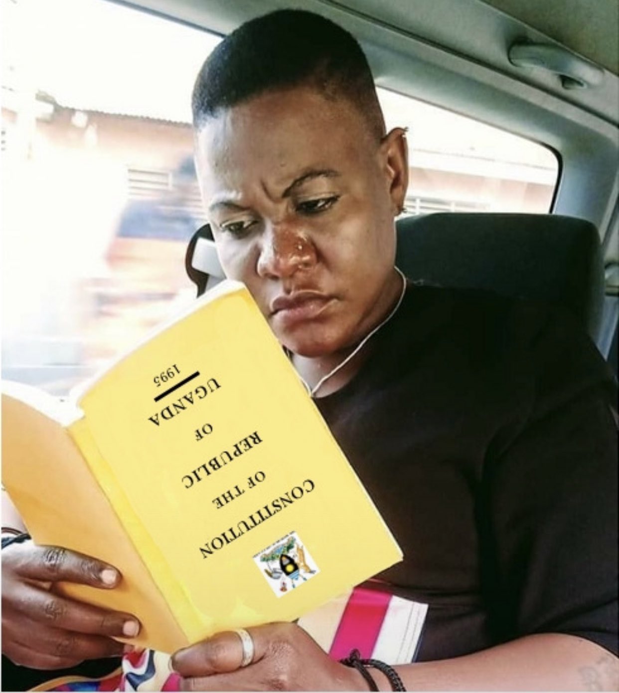 reddit dating - person reading a book upside down - Constitution Of The Republic Of Uganda 1995