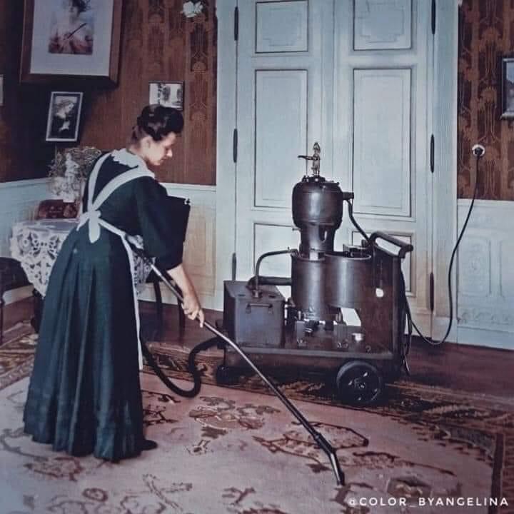 A maid in 1919 vacuuming