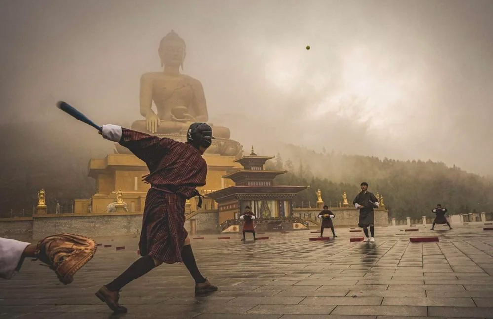 Baseball being played in front of the Great Buddha Dordenma statue, in Bhutan