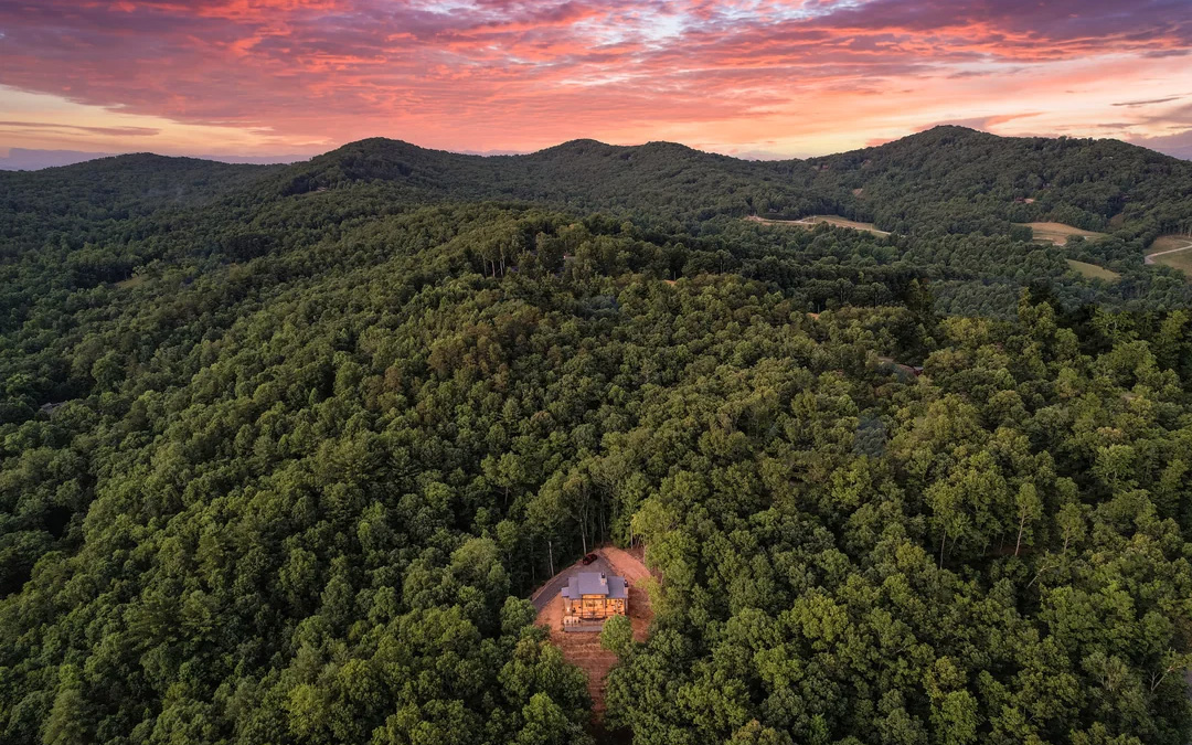 A drone shot of a home tucked away in the hills.