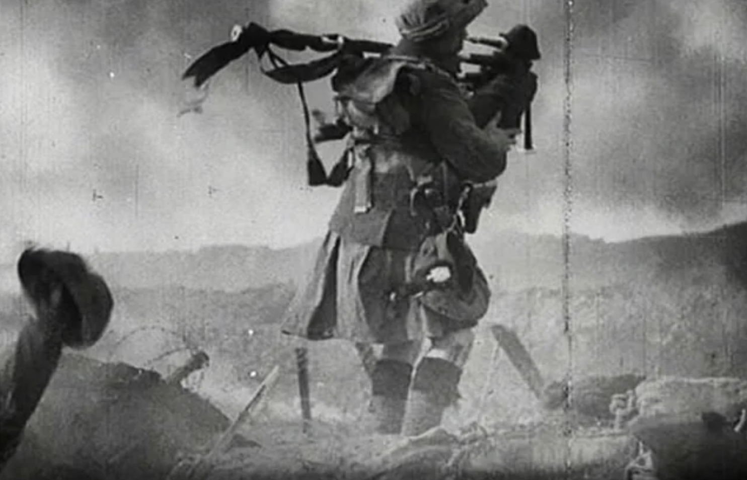 A Scottish piper wearing a kilt enters the battlefield during World War I.