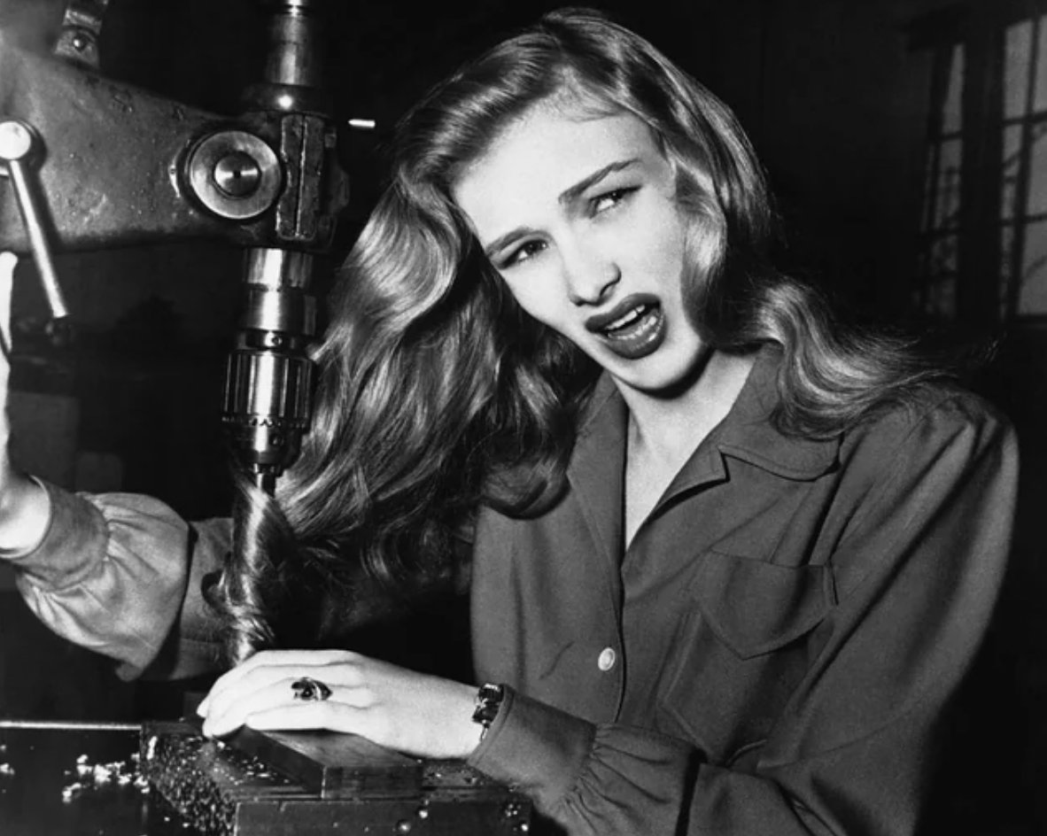 Actress Veronica Lake with her hair twisted in a drill press, demonstrating potential dangers to women in factories during WWII, November 9, 1943.