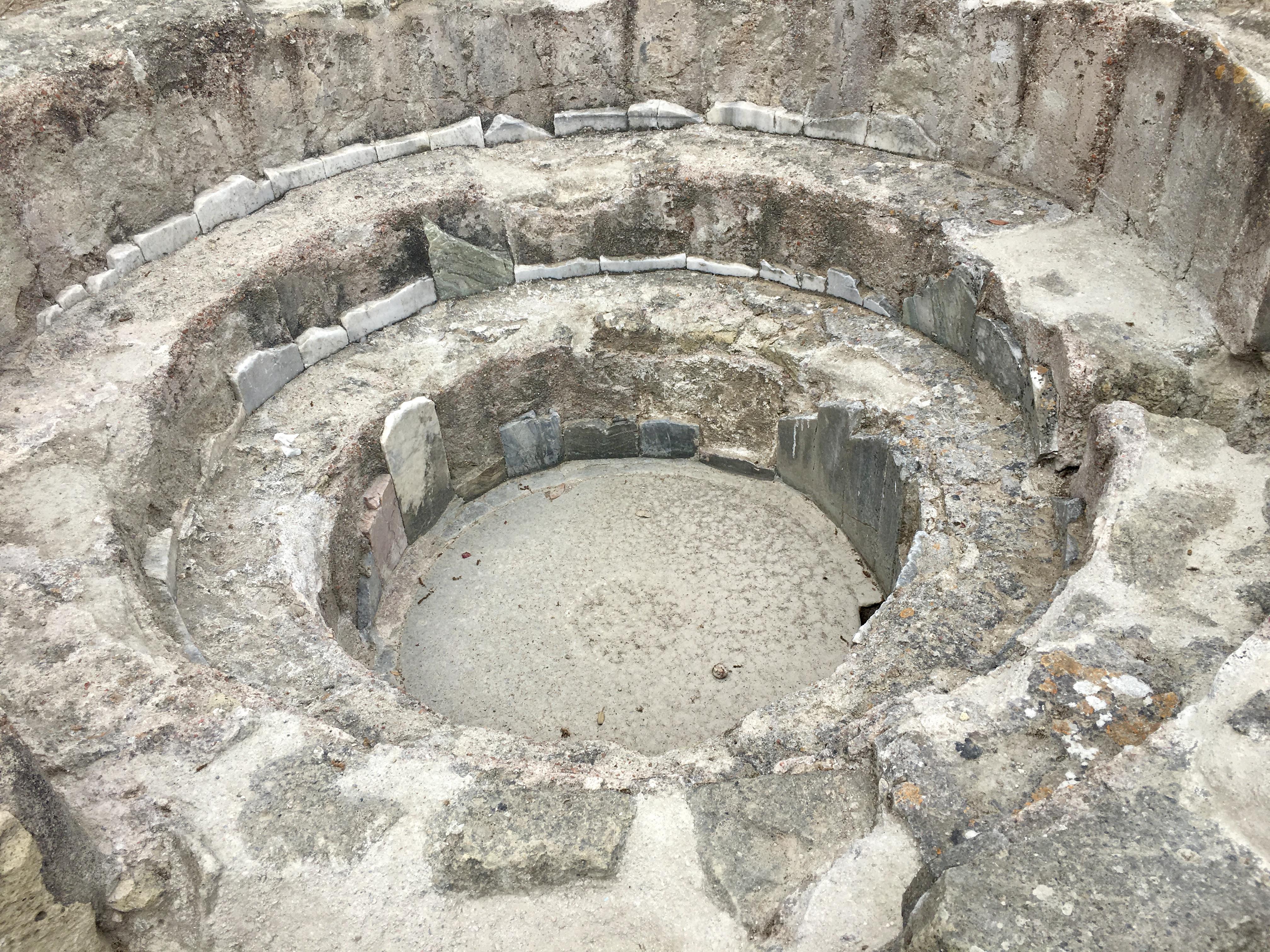 This baptismal fountain was installed by Byzantine settlers circa 500 CE, transforming a Greco-Roman "Temple of Zeus", built 1,000 years earlier, into a Paleochristian basilica. Numerous burials were made in the Archaic sanctuary foundations during Late Antiquity. Cumae Acropolis. Campania, Italy.